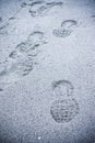 Heavy footprint left on a muddy sand by a male boot.