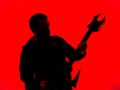 Guitarist with a Heavy Metal Pointed Guitar with Horned Headstock on Red Background Royalty Free Stock Photo