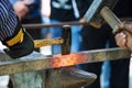 heavy hammer blows on a hot iron, old fashioned blacksmith furnace with burning coals Royalty Free Stock Photo