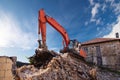A heavy industrial work machine, digger is destroying an abandoned old building Royalty Free Stock Photo