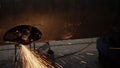 Work grinder cuts metal at the factory. Heavy industry worker cuts a huge pipe Royalty Free Stock Photo