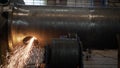 Work grinder cuts metal at the factory. Heavy industry worker cuts a huge pipe Royalty Free Stock Photo