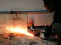 Heavy industry worker cutting steel with angle grinder