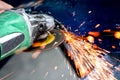 Heavy industry worker cutting steel with angle grinder