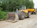 Heavy loader bulldozer bucket. Tractor loader with protective wheel chains on tyre Royalty Free Stock Photo