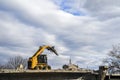 Heavy machinery crushing asphalt for bridge repair