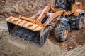 Heavy machinery digs deep into the soil at a construction site in the afternoon, showcasing powerful earthmoving capabilities and Royalty Free Stock Photo