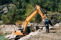 Heavy machinery dragline excavator digging ground in the mountain canyon. Digger ditcher working on a gold mine in the