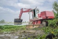 Heavy machinery removing water hyacinth from riverside