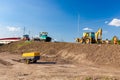 Heavy mechanization on construction site. Tarmac road laying machine, air compressor and excavator parked at building site zone Royalty Free Stock Photo