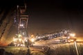 Heavy mining equipment at work in an open-pit mine at dusk