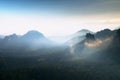 Heavy misty daybreak. Misty daybreak in a beautiful hills. Peaks of hills are sticking out from foggy background.