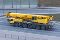 Heavy mobile crane with folding boom construction rides on a city highway Royalty Free Stock Photo