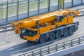 Heavy mobile crane with folding boom construction rides on a city highway Royalty Free Stock Photo