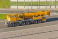 Heavy mobile crane with folding boom construction rides on a city highway Royalty Free Stock Photo