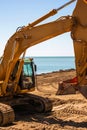 Heavy modern yellow digger excavator on the beach Royalty Free Stock Photo