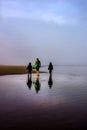 Early morning foggy beach family in vertical layout Royalty Free Stock Photo
