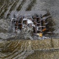 Heavy rain caused flooding in street, water swirling around storm drain Royalty Free Stock Photo