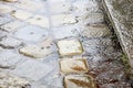 Rain in the city - puddles on the cobblestone street pavement -