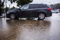 Heavy rain in Israel: a car parked in a parking lot floods with rain, puddle turns to flood Royalty Free Stock Photo