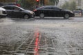 Heavy rain on the sidewalk and asphalt road is illuminated by a red traffic light Royalty Free Stock Photo