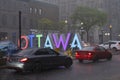 Heavy rain storm in downtown Ottawa, cars driving on the street thru deep puddles of water.