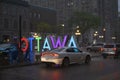 Heavy rain storm in downtown Ottawa, cars driving on the street thru deep puddles of water.