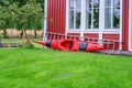 Heavy rain at wooden terrace with summer chairs, wooden table, grill covered against of rain. Blurry green forest at background. Royalty Free Stock Photo