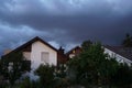 Heavy rainy storm clouds swelling above peaceful residential quarter during twilight