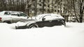Heavy snowfall paralyzed the movement of cars in the city. The car is covered in snow. Consequences of heavy snowfall in the city