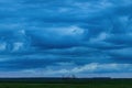 Heavy storm clouds at sky above countryside landscape in dusk Royalty Free Stock Photo