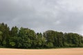 Heavy, thick, thunder, stormy, rainy clouds over the mixed forest with harvested field Royalty Free Stock Photo