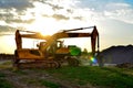 Heavy tracked excavator at a construction site on a background of a residential building and construction cranes on a sunny day Royalty Free Stock Photo