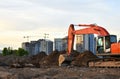 Heavy tracked excavator at a construction site on a background of a residential building and construction cranes on a sunny day Royalty Free Stock Photo