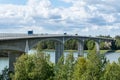 Heavy traffic crossing a bridge over water in sunshine