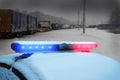 Heavy truck traffic jam on snowy winter ice highway. Police car under snow. Emergency warning flashing red and blue led lights. Royalty Free Stock Photo