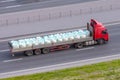 Heavy truck with trailer and bulk cargo in bags- industrial sulfur, chemicals, poisons, dangerous goods rides on the highway in