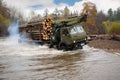 Heavy truck for transportation of logs moves ford in the river Royalty Free Stock Photo