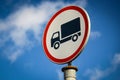 Heavy vihicle round white and red road sign with black truck on blue sky backgound