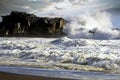 Heavy violent surf waves crashing on secluded black lava sand beach and rock, one bird, misty sea water spray and foam  - Royalty Free Stock Photo