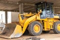 Heavy wheel loader with a bucket at a construction site. Close-up. Equipment for earthworks, transportation and loading of bulk