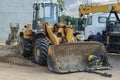 Heavy wheel loader with a bucket at a construction site. Equipment for earthworks, transportation and loading of bulk materials -