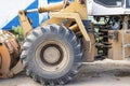 Heavy wheel loader with a bucket at a construction site. Equipment for earthworks, transportation and loading of bulk materials -