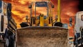 Heavy wheel loader with a bucket at a construction site surrounded by dump trucks against the backdrop of a red sunset sky. Close- Royalty Free Stock Photo