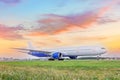 Heavy wide-body long-haul jet aircraft taxis to the runway for takeoff, against the backdrop of a beautiful dawn sunset sky Royalty Free Stock Photo