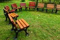 Wood and cast iron garden chairs placed in circle with green grass Royalty Free Stock Photo