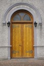 Heavy wooden arched door with ornate hinges