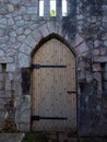 Heavy wooden castle single door with metal bands and studs.  Medieval style set in a stone block wall Royalty Free Stock Photo