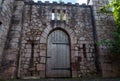 Heavy wooden castle single door with metal bands and studs. Medieval style set in a stone block wall