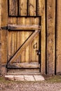 A heavy wooden door, locked from the outside, to an old wood-sid Royalty Free Stock Photo